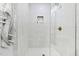 Glass shower shows the tiled shower walls, gold shower head and shelf for bath products at 947 Manchester Dr, Cary, NC 27511
