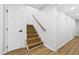 Staircase features wood stairs, a white door and handrail at 947 Manchester Dr, Cary, NC 27511