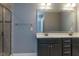 Bathroom featuring double sinks with black cabinets, a large mirror, and modern lighting fixtures at 996 Tender Dr, Apex, NC 27502