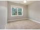 Bedroom showcasing neutral carpet, light gray walls, and a large window offering natural light at 996 Tender Dr, Apex, NC 27502