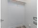 Empty closet with a wooden clothes rack, white walls, and laminate flooring at 996 Tender Dr, Apex, NC 27502