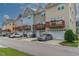 Street view of colorful townhomes featuring attached garages and balconies at 996 Tender Dr, Apex, NC 27502