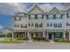 Charming exterior of townhomes with inviting front porches, colorful facades, and manicured landscaping at 996 Tender Dr, Apex, NC 27502