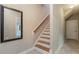Bright hallway with stairs featuring wood treads, a large mirror, and a neutral color palette at 996 Tender Dr, Apex, NC 27502