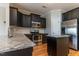 Well-equipped kitchen featuring granite countertops, stainless steel appliances, an island and dark cabinets with a stylish subway backsplash at 996 Tender Dr, Apex, NC 27502