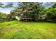 View of a lush, green backyard with mature trees and partial view of the house at 1016 Pasture View Ln, Raleigh, NC 27603