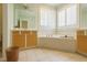 Bathroom with a soaking tub, double windows with plantation shutters, and ample storage at 1016 Pasture View Ln, Raleigh, NC 27603