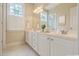 Bright bathroom featuring white double vanities with plentiful storage and a large mirror at 1016 Pasture View Ln, Raleigh, NC 27603