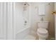 Bathroom with a shower-tub combo, white shower curtain, white tile, and modern fixtures at 1016 Pasture View Ln, Raleigh, NC 27603