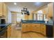 Bright kitchen featuring honey-colored wood cabinetry, dark countertops, and an adjacent breakfast nook at 1016 Pasture View Ln, Raleigh, NC 27603