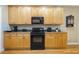 Kitchen area features plentiful honey-colored wood cabinets, black appliances, and sleek countertops at 1016 Pasture View Ln, Raleigh, NC 27603