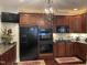 Well-equipped kitchen featuring dark wood cabinets, black appliances, and elegant chandelier at 10411 Rosegate Court # 6, Raleigh, NC 27617