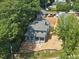 New construction exterior elevation of a blue home with a gray roof surrounded by mature trees and a partially landscaped yard at 1221 Dixie Trl, Raleigh, NC 27607