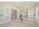Unfinished living room featuring white walls, built-in bookshelves, large windows, and natural light at 1221 Dixie Trl, Raleigh, NC 27607