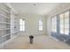 Unfinished living room featuring white walls, built-in bookshelves, large windows, and natural light at 1221 Dixie Trl, Raleigh, NC 27607