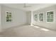 A large bedroom is filled with natural light from three windows awaiting personalized flooring at 1225 Dixie Trl, Raleigh, NC 27607
