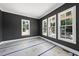 A room with dark gray walls and white trim, featuring three large windows letting in natural light at 1225 Dixie Trl, Raleigh, NC 27607