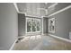Bedroom featuring a modern ceiling fan, gray walls, and large windows providing natural light at 1229 Dixie Trl, Raleigh, NC 27607