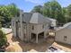 Rear exterior elevation of a two-story home featuring a chimney and covered patio at 1229 Dixie Trl, Raleigh, NC 27607
