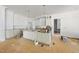 Spacious kitchen with white cabinets, large island, and modern lighting fixtures at 1229 Dixie Trl, Raleigh, NC 27607