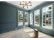 Living room featuring trim, paneled walls, multiple windows, and stylish lighting fixture at 1229 Dixie Trl, Raleigh, NC 27607