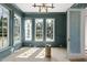 Living room featuring trim, paneled walls, multiple windows, stylish lighting fixture, and a doorway at 1229 Dixie Trl, Raleigh, NC 27607