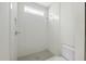 Modern walk-in shower with white tile and penny tile floor, complemented by sleek fixtures at 1229 Dixie Trl, Raleigh, NC 27607