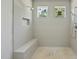 Bright shower featuring neutral tile, bench seat, tiled niche, and dual shower heads at 1229 Dixie Trl, Raleigh, NC 27607