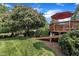 A wooden deck with an umbrella provides access to a grassy backyard and shaded area at 12412 Mayhurst Pl, Raleigh, NC 27614