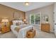 Cozy bedroom with natural light, a wicker bed frame, a window with blinds, and wicker bedside tables at 12412 Mayhurst Pl, Raleigh, NC 27614