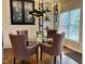 Stylish dining room with glass-top table, modern chandelier, and floor-to-ceiling wine racks at 12412 Mayhurst Pl, Raleigh, NC 27614