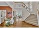 Grand foyer with staircase, hardwood floors, and views into the living spaces at 12412 Mayhurst Pl, Raleigh, NC 27614