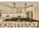 Modern kitchen featuring a dark countertop island, stainless steel appliances, and stylish pendant lights at 12412 Mayhurst Pl, Raleigh, NC 27614