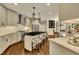 Open-concept kitchen with hardwood floors, island with bar seating, stainless appliances, and elegant pendant lighting at 12412 Mayhurst Pl, Raleigh, NC 27614