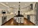 Spacious open kitchen with island, stainless appliances, and hardwood floors, perfect for entertaining at 12412 Mayhurst Pl, Raleigh, NC 27614