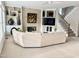 Bright living room with fireplace, built-in shelving, and staircase at 12412 Mayhurst Pl, Raleigh, NC 27614
