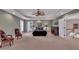 Large main bedroom with a tray ceiling, ceiling fan, a seating area, and plenty of space at 12412 Mayhurst Pl, Raleigh, NC 27614