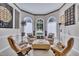 Cozy sitting room with three large arched windows and comfortable seating arrangement at 12412 Mayhurst Pl, Raleigh, NC 27614