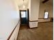 Inviting entryway featuring a carpeted floor, trim work, and a front door that lets in natural light at 1306 Oakridge Ave, Henderson, NC 27536