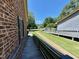 Exterior showing brick wall, wooden deck, and green lawn at 1306 Oakridge Ave, Henderson, NC 27536