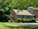 Charming single-Gathering home with a blend of brick and siding surrounded by mature trees and landscaping at 1306 Oakridge Ave, Henderson, NC 27536