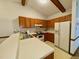 Bright kitchen with white countertops, wood cabinets, white appliances, and neutral flooring at 1306 Oakridge Ave, Henderson, NC 27536