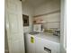 Laundry room featuring washer, dryer, electrical panel, and shelves at 1306 Oakridge Ave, Henderson, NC 27536