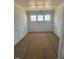 Bright living room with three windows, white walls, wainscotting, and coffered ceilings at 140 Sawtooth Oak Ln, Youngsville, NC 27596