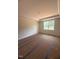 Large main bedroom with trey ceilings, neutral walls and a large window with a wooded view at 140 Sawtooth Oak Ln, Youngsville, NC 27596