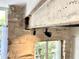 Close-up of an exposed stone wall with timber beams and track lighting, showcasing the home's architectural details at 1500 River Mill Dr # 310, Wake Forest, NC 27587