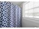 Blue pattern shower curtain hangs near the window at 1500 River Mill Dr # 310, Wake Forest, NC 27587