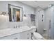 Bathroom with marble countertop, white cabinets, a glass-enclosed shower, and modern fixtures and hardware at 1500 River Mill Dr # 310, Wake Forest, NC 27587
