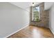 Bedroom featuring exposed stone wall, hardwood floors, a large window, and ample natural light at 1500 River Mill Dr # 310, Wake Forest, NC 27587