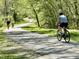 Picturesque tree-lined bike path with cyclists enjoying a ride, showcasing an active and outdoor lifestyle at 1500 River Mill Dr # 310, Wake Forest, NC 27587
